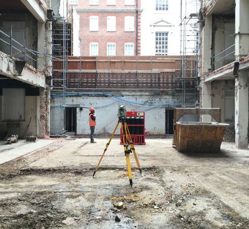 Site operative doing a survey on a run down building